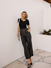 a lady wears a black seamless knit top with black leather pants